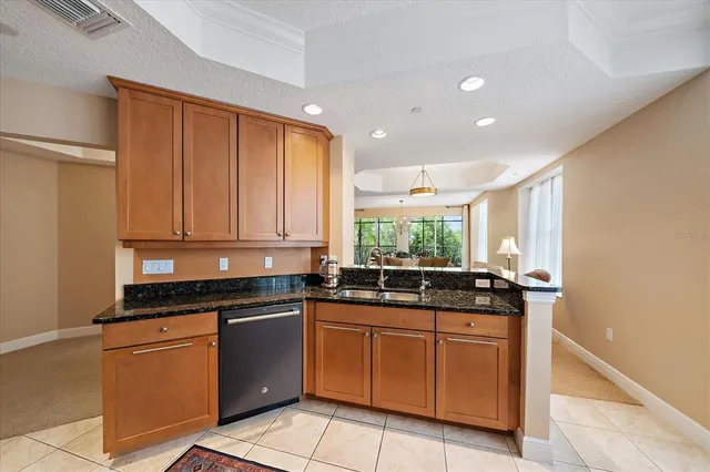 a kitchen with granite countertop a sink and white cabinets