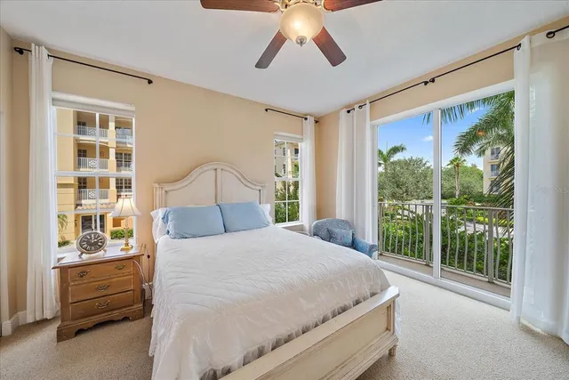 a bedroom with a bed dresser and a large window
