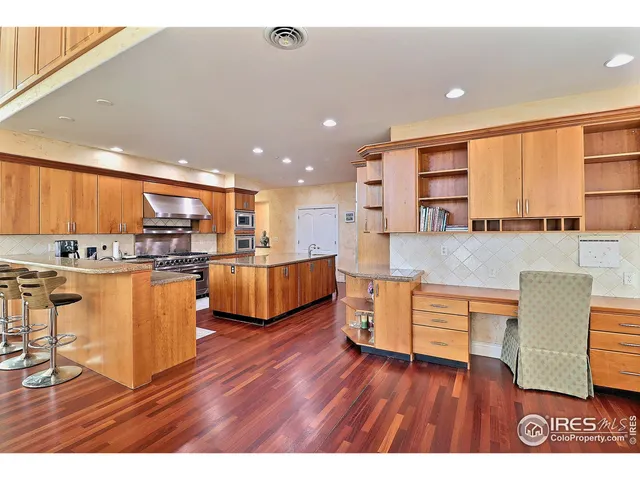 a living room with furniture wooden floor and a kitchen view