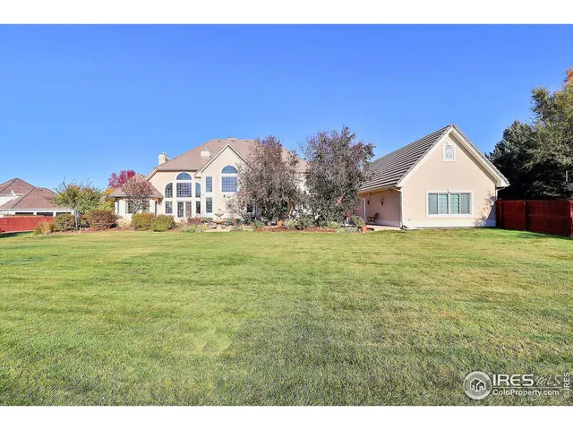 a view of a white house with a yard and sitting area