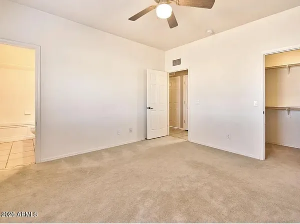 an empty room with a ceiling fan and a window