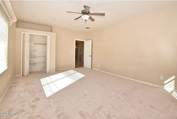 an empty room with fan and windows