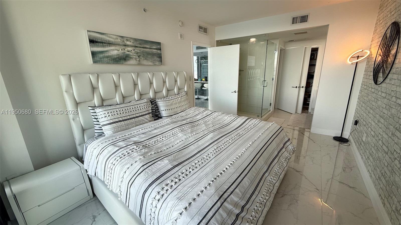 460 Northeast 28th Street, Unit 608 Miami, FL 33137 - Photo 7 of 10 a bedroom with a bed and a mirror
