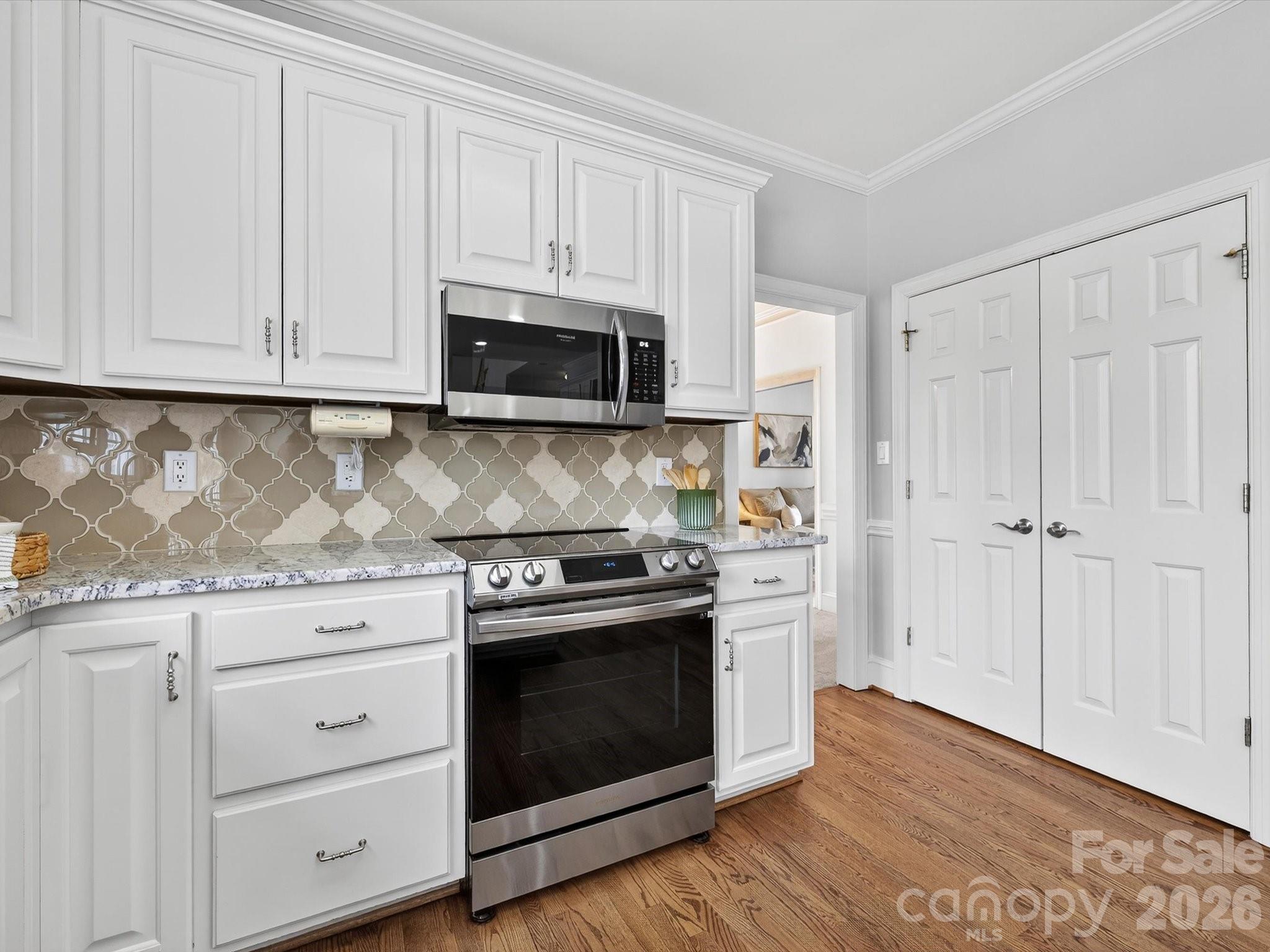 13417 Scanlan Way Davidson, NC 28036 - Photo 14 of 48 a kitchen with white cabinets and stainless steel appliances