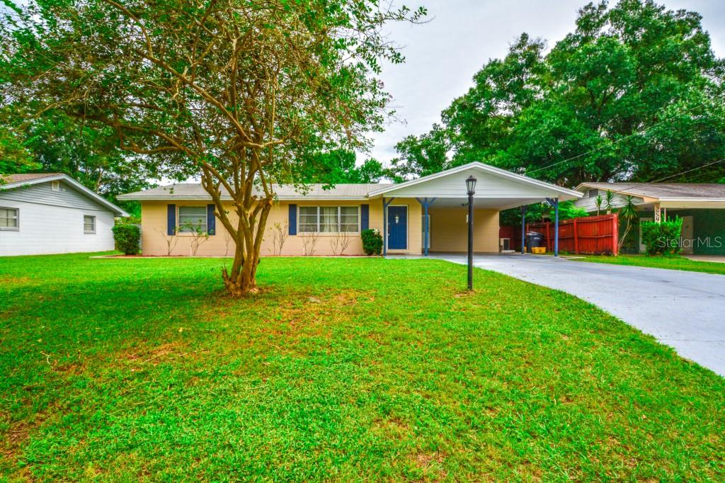 a front view of a house with a yard and trees