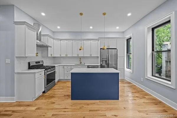a living room with stainless steel appliances kitchen island granite countertop furniture and a wooden floor
