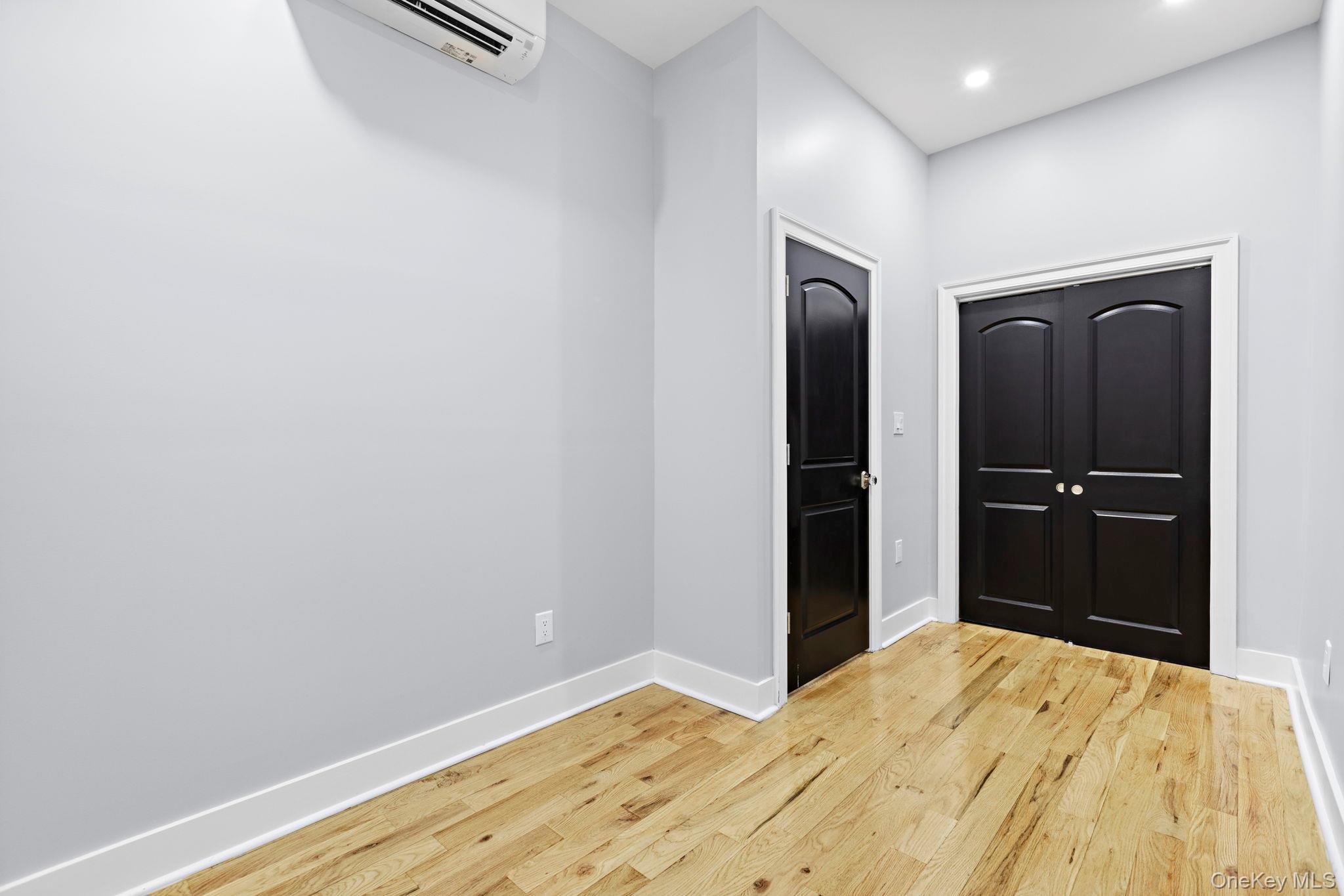 581 Decatur Street Brooklyn, NY 11233 - Photo 10 of 12 a bedroom with a bed and wooden floor