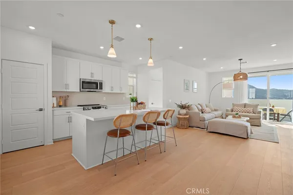 a kitchen with a sink dishwasher and white cabinets with wooden floor
