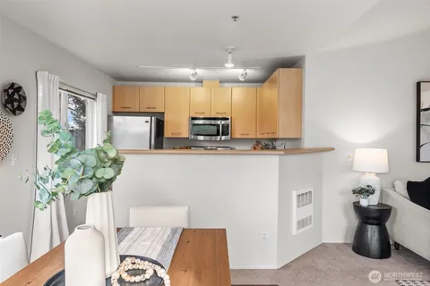 a kitchen with stainless steel appliances kitchen island granite countertop a table and chairs in it
