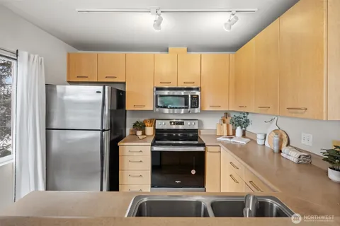a kitchen with a refrigerator a stove a sink and a counter top space