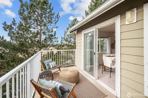 a balcony with wooden floor table and chairs