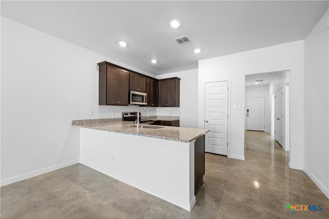 2819 Quail Rdg Lane Temple, TX 76501 - Photo 6 of 17 a kitchen with stainless steel appliances granite countertop a sink stove and refrigerator