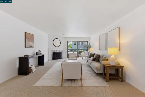 a living room with furniture a fireplace and a window