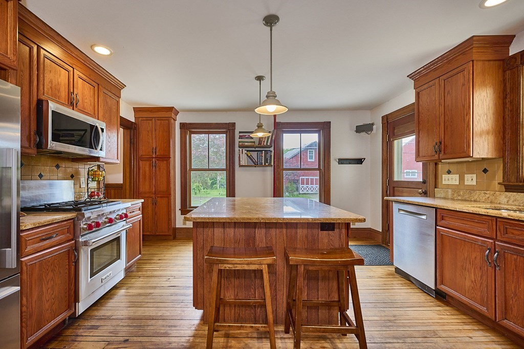 39 Laurel Mountain Road Haydenville, MA 01039 - Photo 5 of 42 a kitchen with stainless steel appliances a stove a sink dishwasher a microwave oven and a dining table with wooden floor