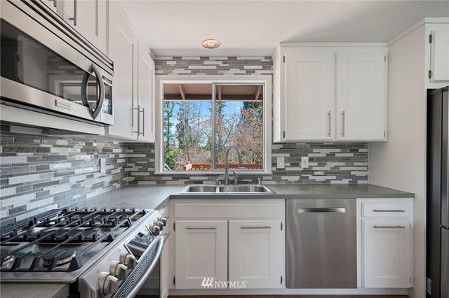 a kitchen with stainless steel appliances granite countertop a stove and a sink