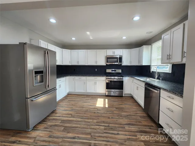 a large kitchen with cabinets stainless steel appliances and a counter space