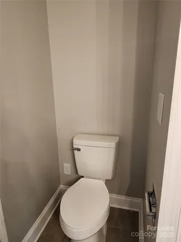 a white toilet sitting next to a small window