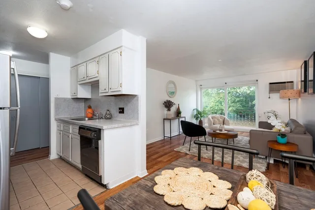 a kitchen with stainless steel appliances granite countertop a stove refrigerator and a dining table with kitchen view
