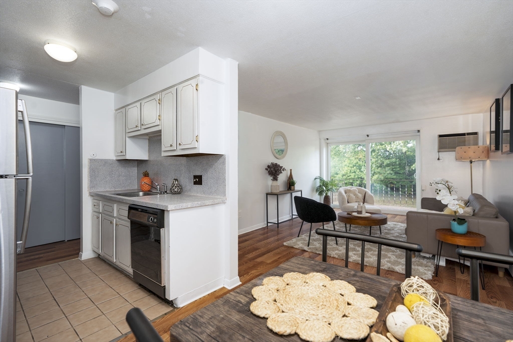426 Pleasant Street, Unit 17 Malden, MA 02148 - Photo 13 of 36 a kitchen with stainless steel appliances granite countertop a stove refrigerator and a dining table with kitchen view