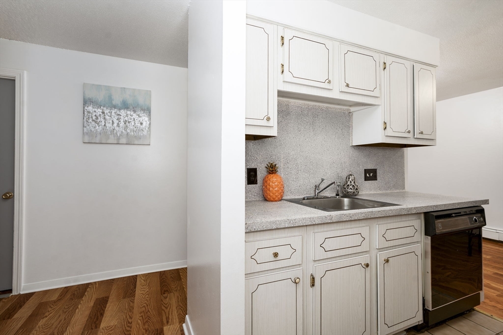426 Pleasant Street, Unit 17 Malden, MA 02148 - Photo 18 of 36 a kitchen with white cabinets and a sink