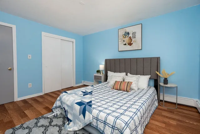 a bedroom with a bed and wooden floor