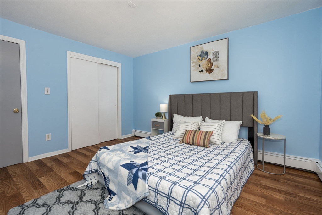 426 Pleasant Street, Unit 17 Malden, MA 02148 - Photo 23 of 36 a bedroom with a bed and wooden floor