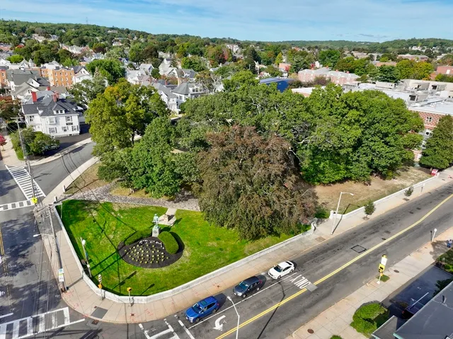 an aerial view of a residential houses with outdoor space and street view