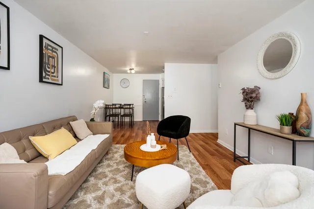 a living room with furniture and a wooden floor