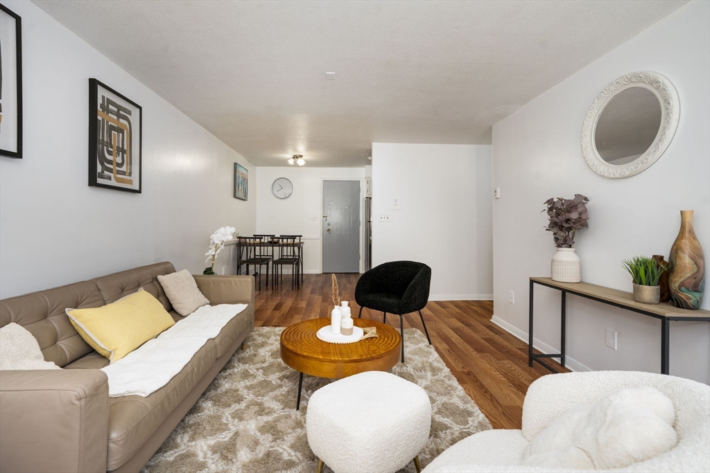 426 Pleasant Street, Unit 17 Malden, MA 02148 - Photo 5 of 36 a living room with furniture and a wooden floor