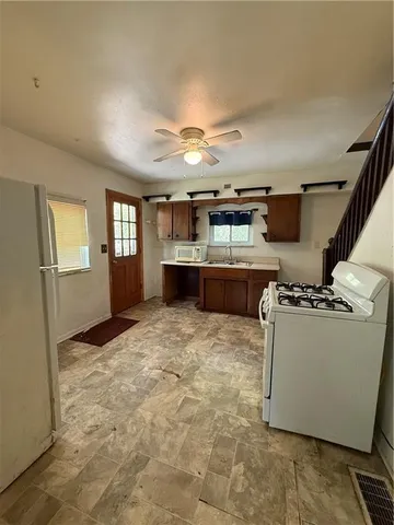 a large kitchen with kitchen island granite countertop a stove and a refrigerator