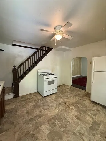 a view of a livingroom with a ceiling fan and staircase