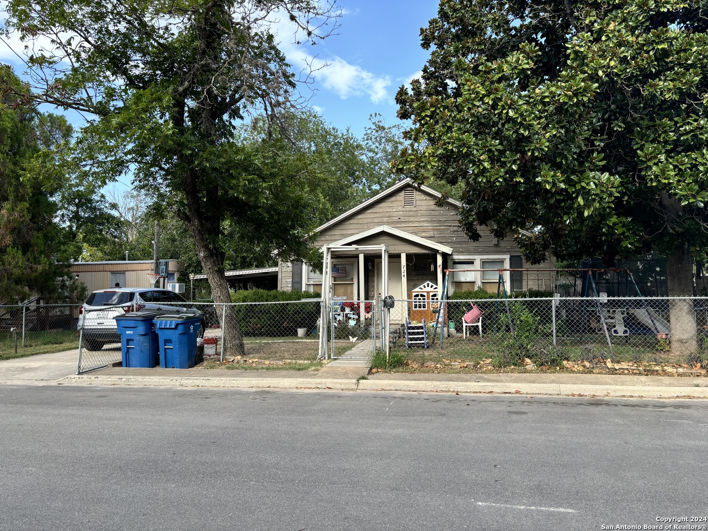724 Ormond Street Pleasanton, TX 78064 - Photo 2 of 4 a front view of a house with swing and plants