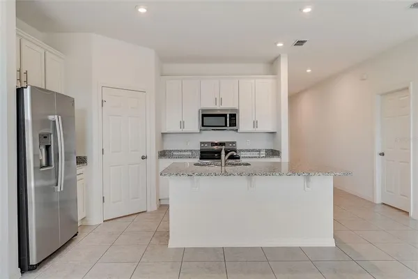 a large kitchen with cabinets and stainless steel appliances
