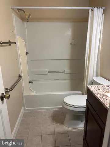 a bathroom with a granite countertop toilet sink and shower
