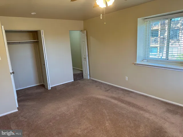 an empty room with windows and closet