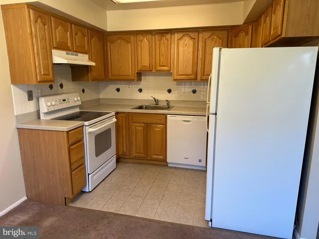 a kitchen with stainless steel appliances white cabinets and a refrigerator