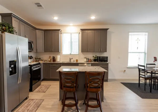 a kitchen with stainless steel appliances granite countertop a refrigerator and a sink