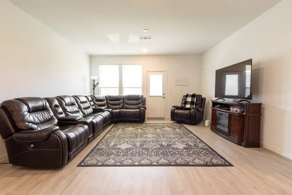 a bedroom with furniture and a wooden floor