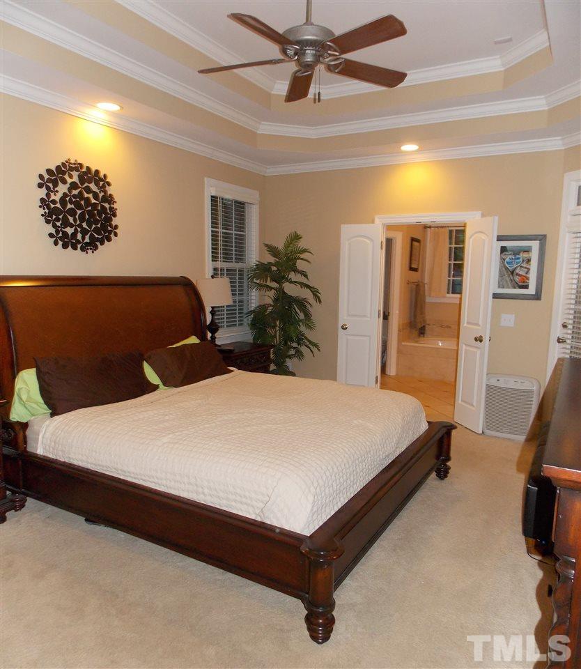 1840 Bowling Green Trail Raleigh, NC 27613 - Photo 5 of 16 a bedroom with a bed and a chandelier