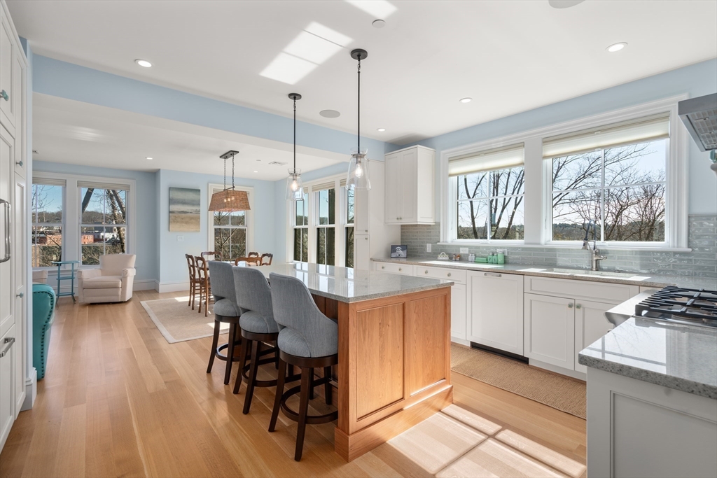 16 Everett Street, Unit 202 Boston, MA 02130 - Photo 5 of 19 a kitchen with stainless steel appliances granite countertop a stove top oven a sink dishwasher a dining table and chairs with wooden floor