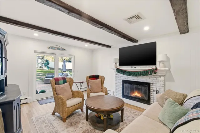 a living room with furniture a flat screen tv and a fireplace