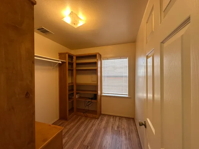 an empty room with windows and fan