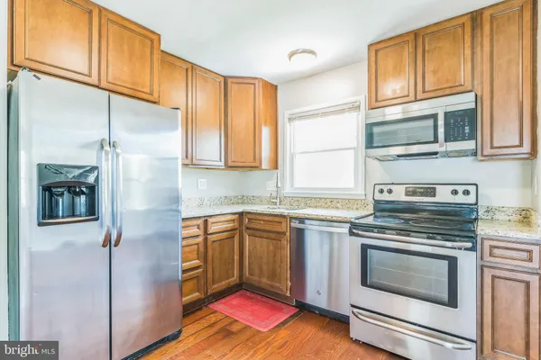 a kitchen with stainless steel appliances granite countertop a stove and a refrigerator