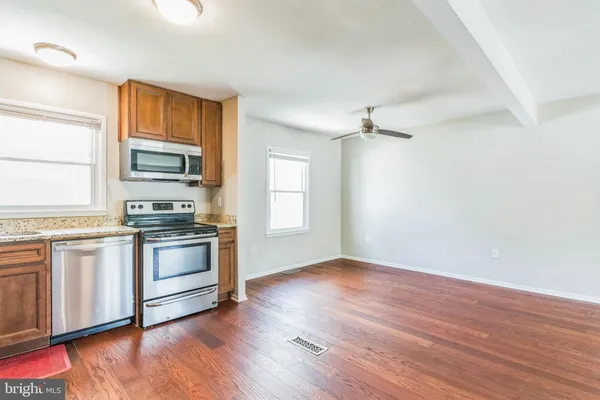 a kitchen with granite countertop wooden floors and stainless steel appliances