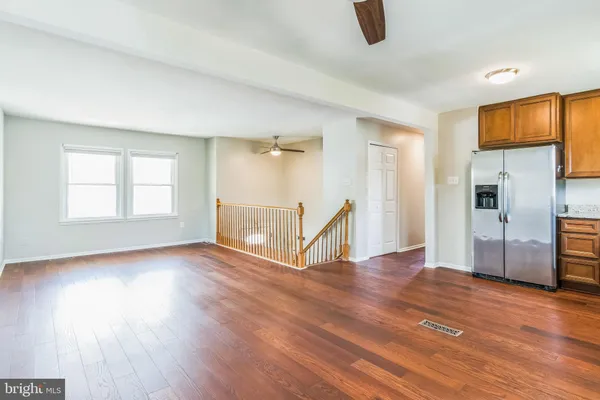 a view of empty room with wooden floor and window