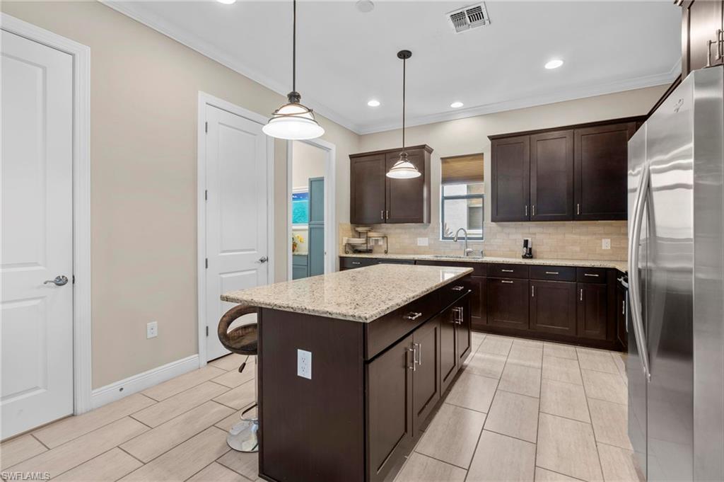 1300 Kendari Terrace Naples, FL 34113 - Photo 12 of 31 a kitchen with stainless steel appliances granite countertop a sink a stove and a refrigerator
