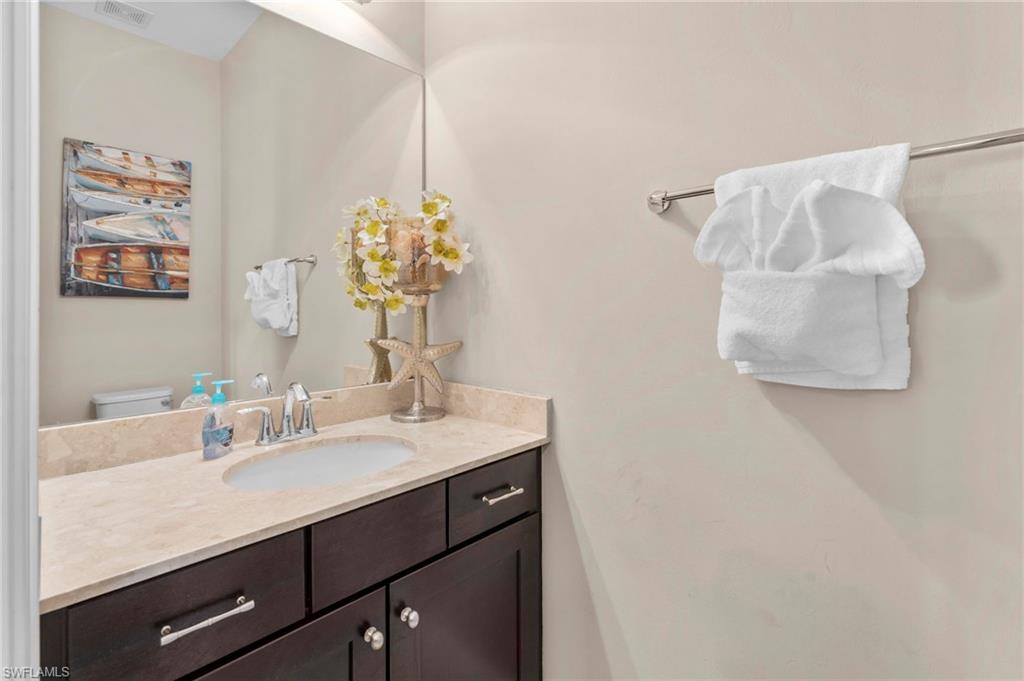 1300 Kendari Terrace Naples, FL 34113 - Photo 13 of 31 a bathroom with a sink vanity and a mirror