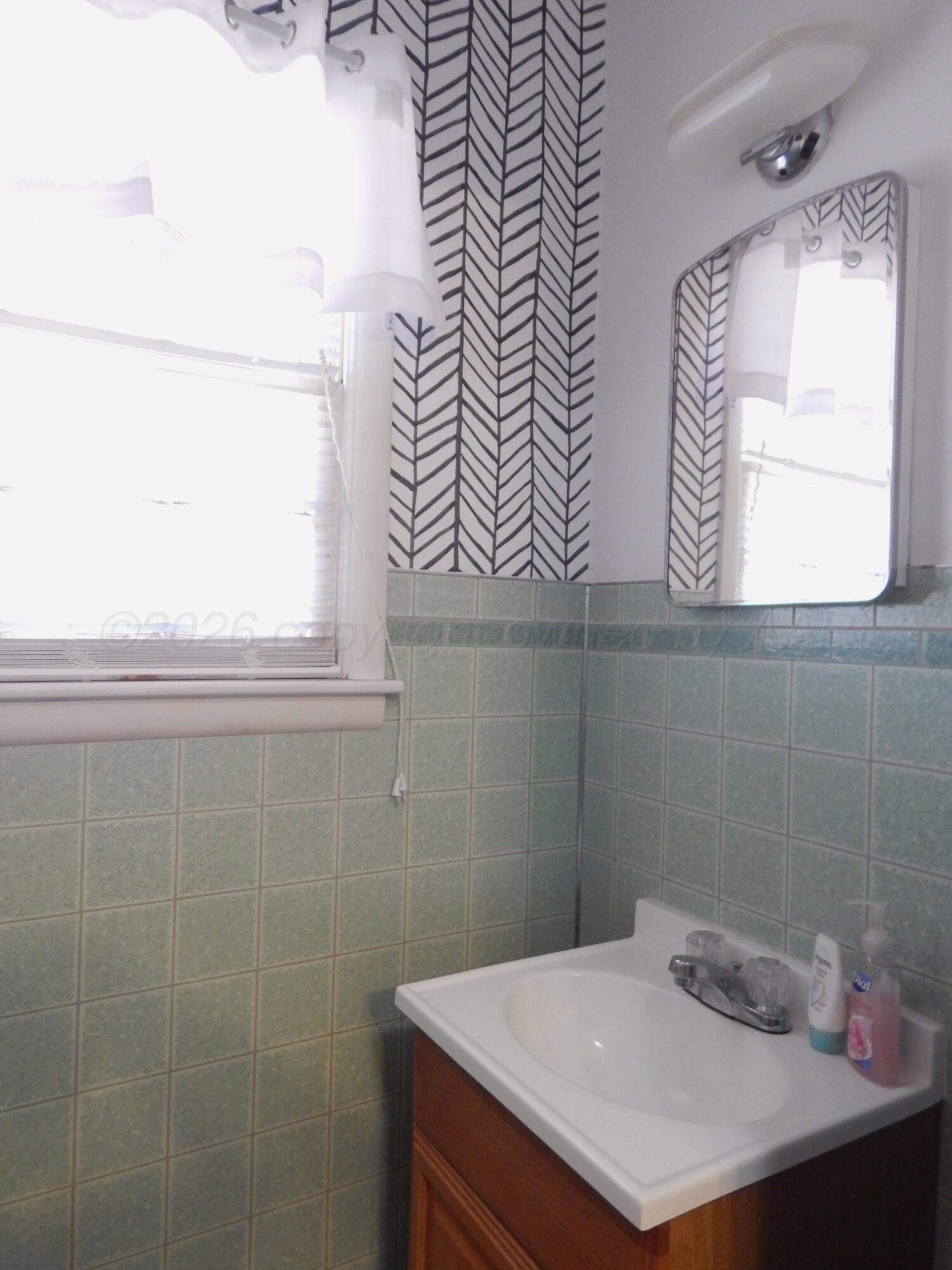 519 Third Street McLean, TX 79057 - Photo 11 of 19 a bathroom with a sink a vanity and a mirror