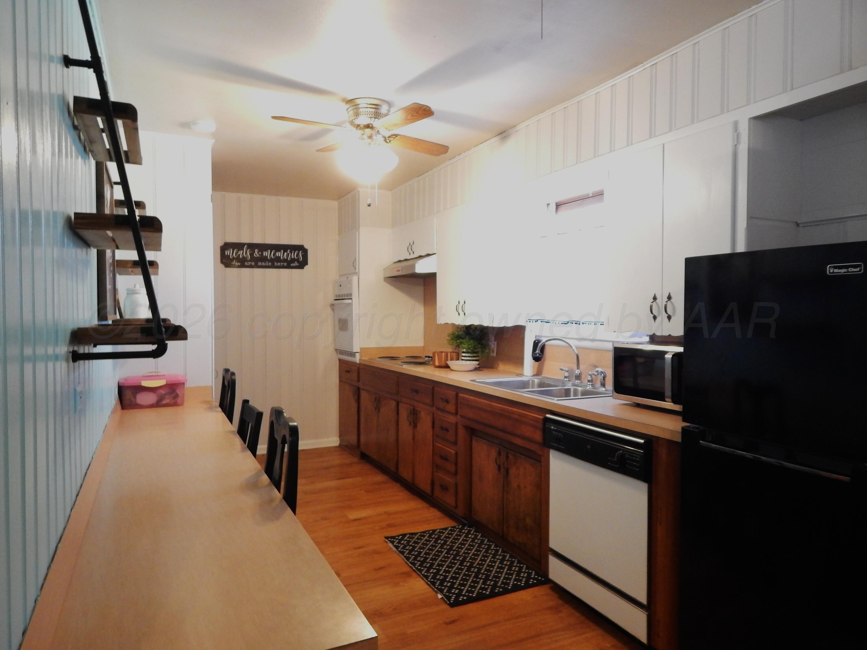519 Third Street McLean, TX 79057 - Photo 5 of 19 a kitchen with stainless steel appliances a sink stove and refrigerator