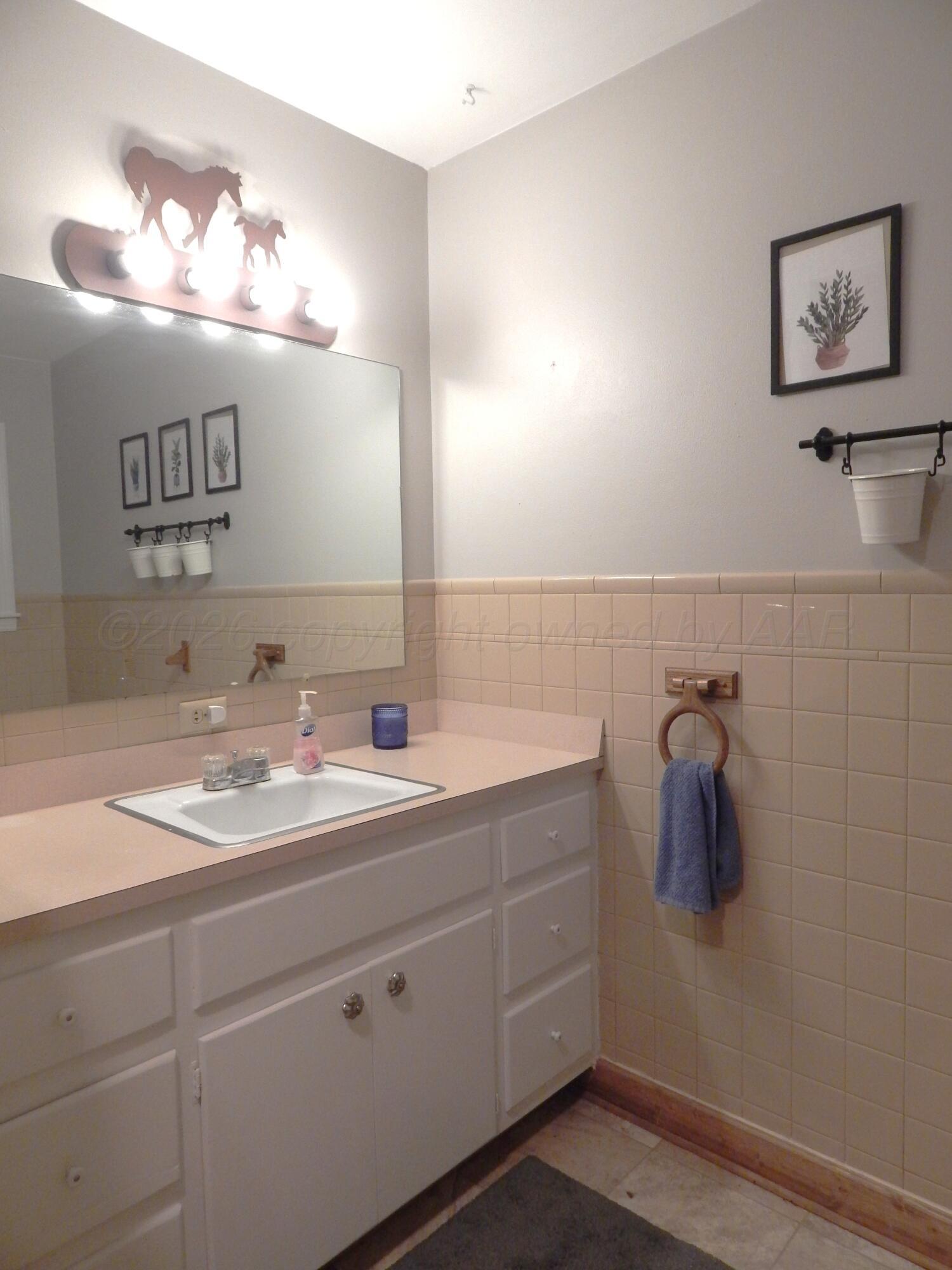 519 Third Street McLean, TX 79057 - Photo 9 of 19 a bathroom with a sink and mirror